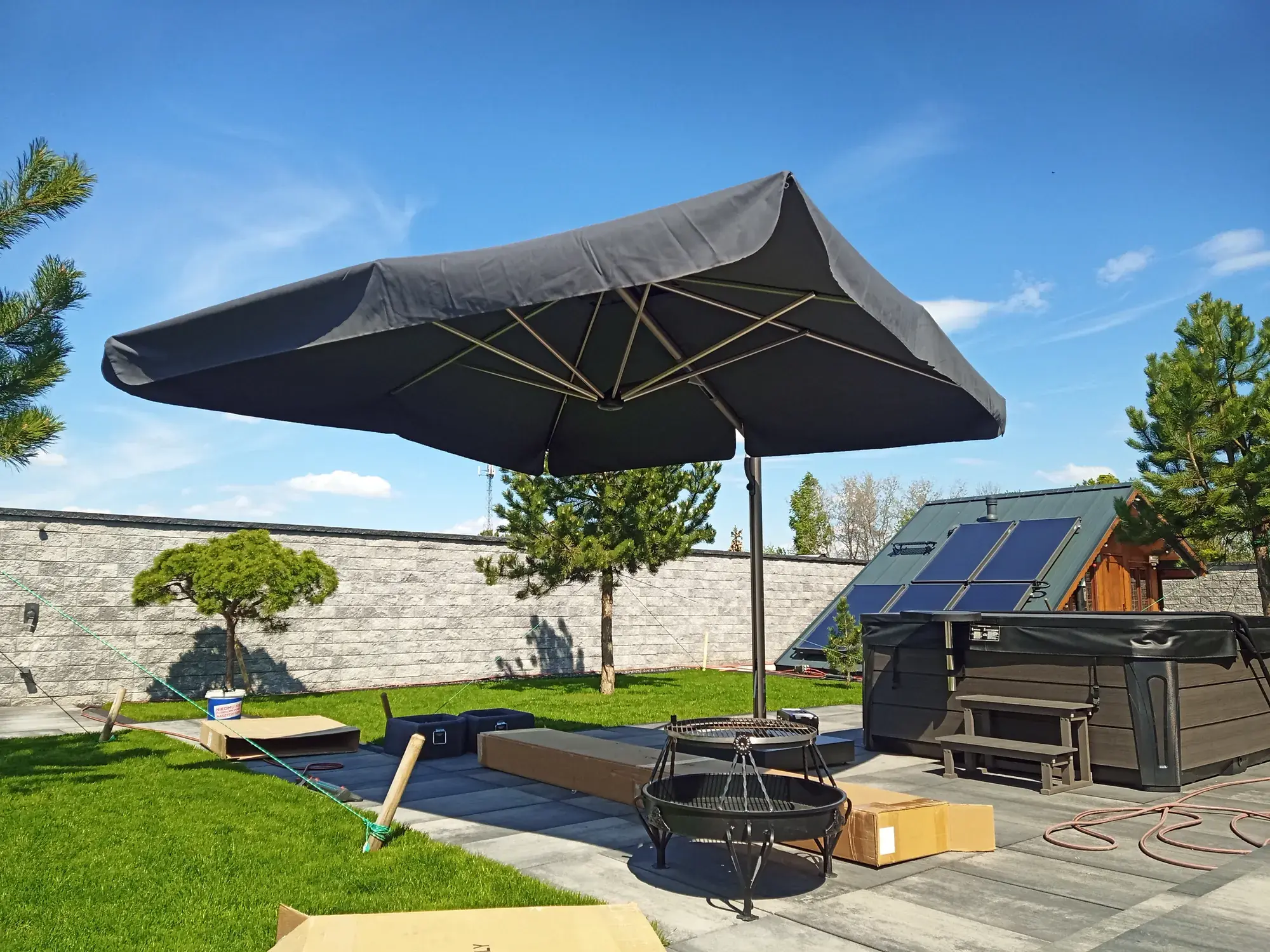 Astro Titanium with a dark canopy by the hot tub, seen from the other side of the garden