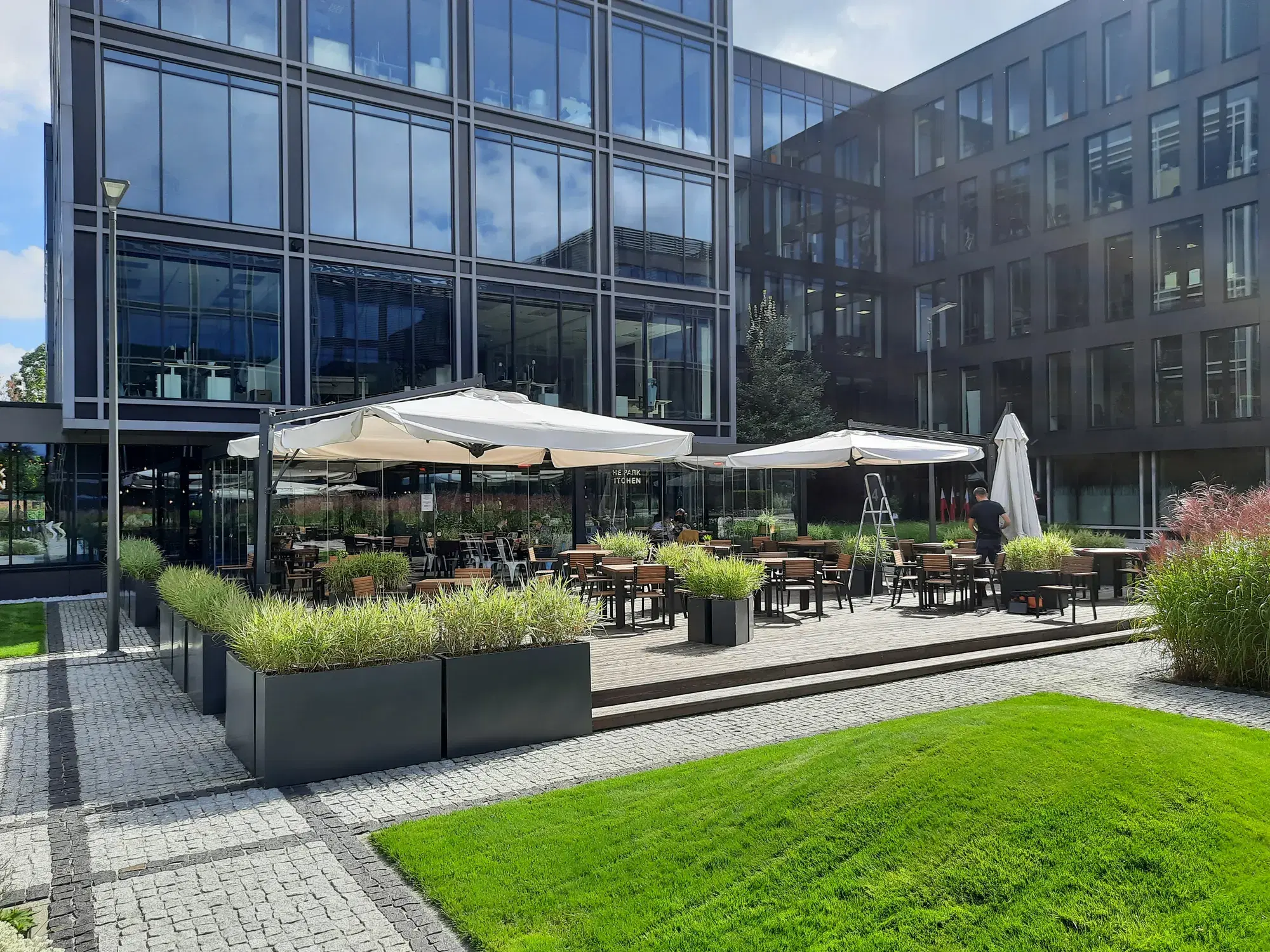 Restaurantgarten zwischen den Bürogebäuden von The Park Warsaw mit Scolaro-Sonnenschirmen